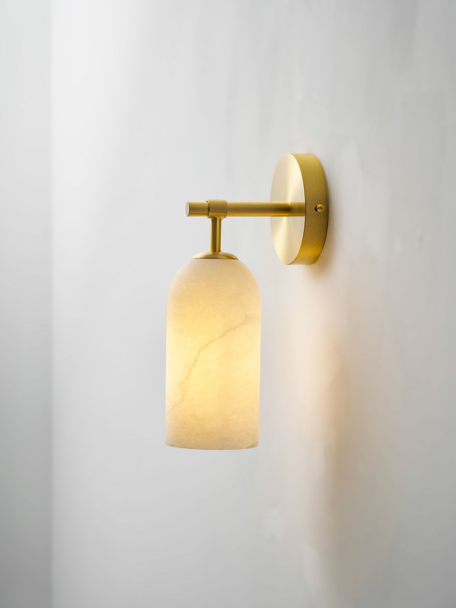 Lampada da parete cilindrica in alabastro con luce calda e cornice dorata